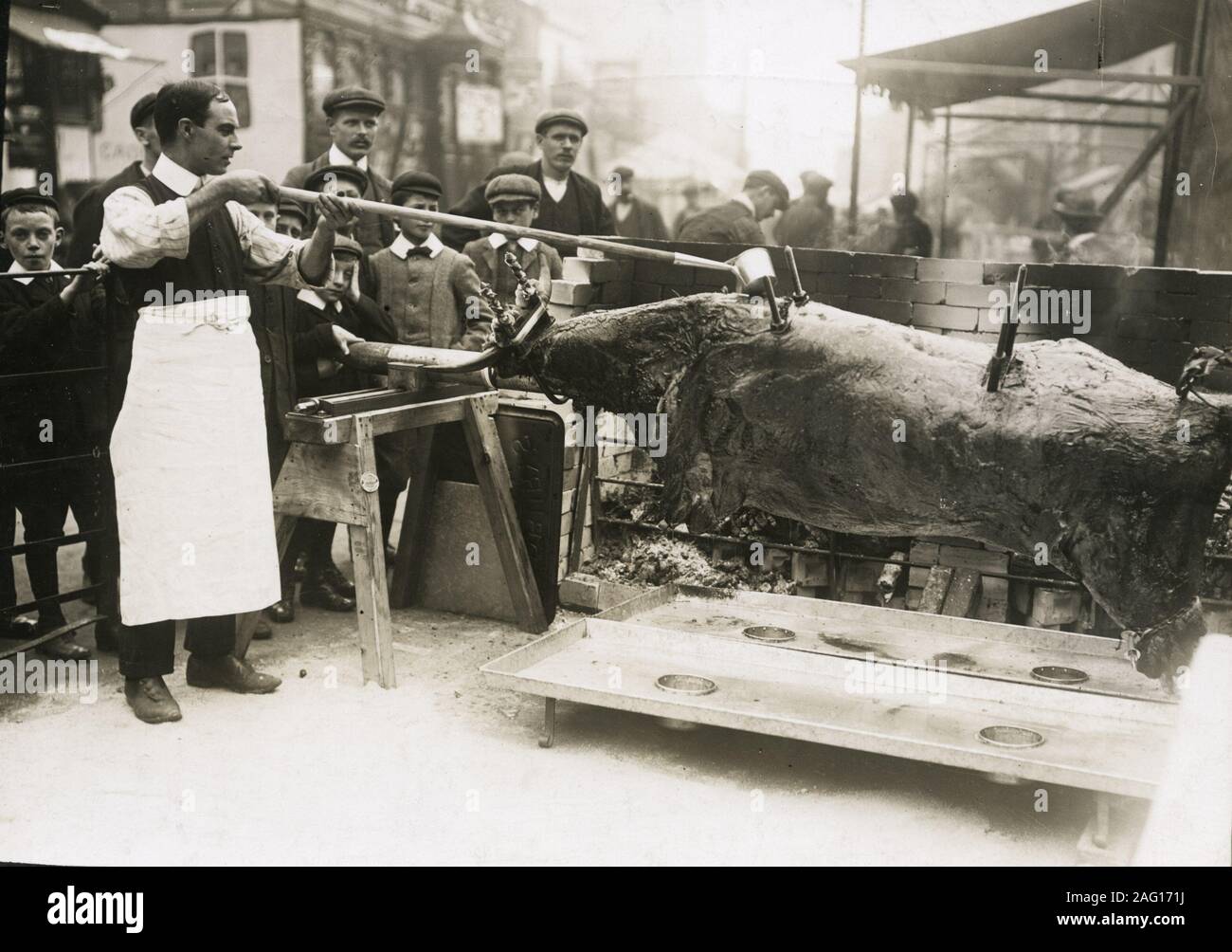 Early 20th century vintage press photograph - roasting an ox in the street at the Stratford Mop Fair in the 1920s Stock Photo