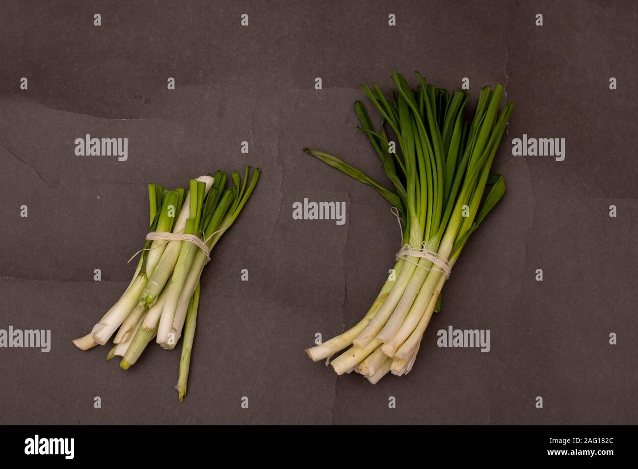 Green Onions on black table, top view and copy space Stock Photo - Alamy