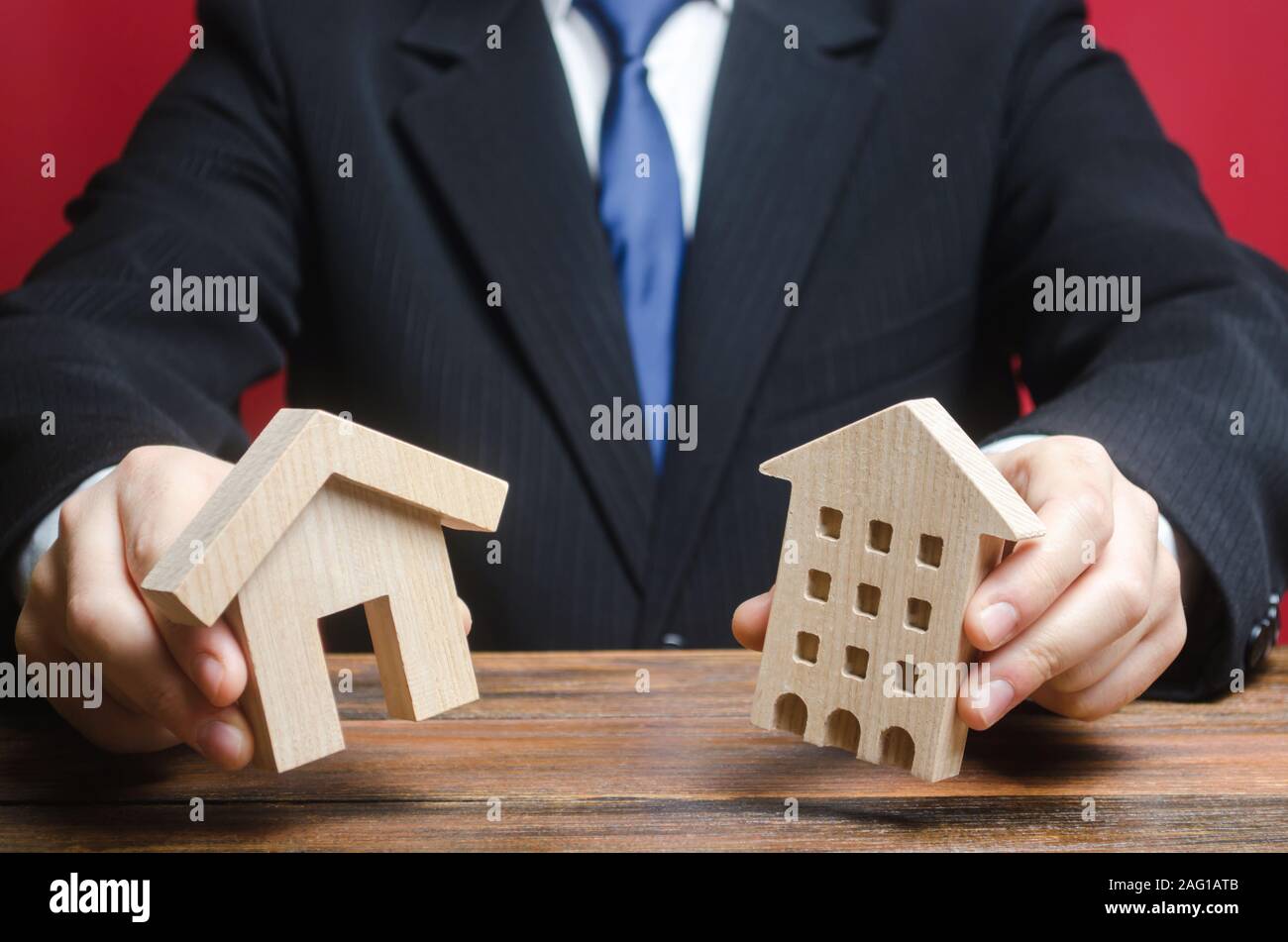 A man makes a choice between a private house and an apartment. Type of optimal convenient housing. Definition housing for current needs, location. Mor Stock Photo