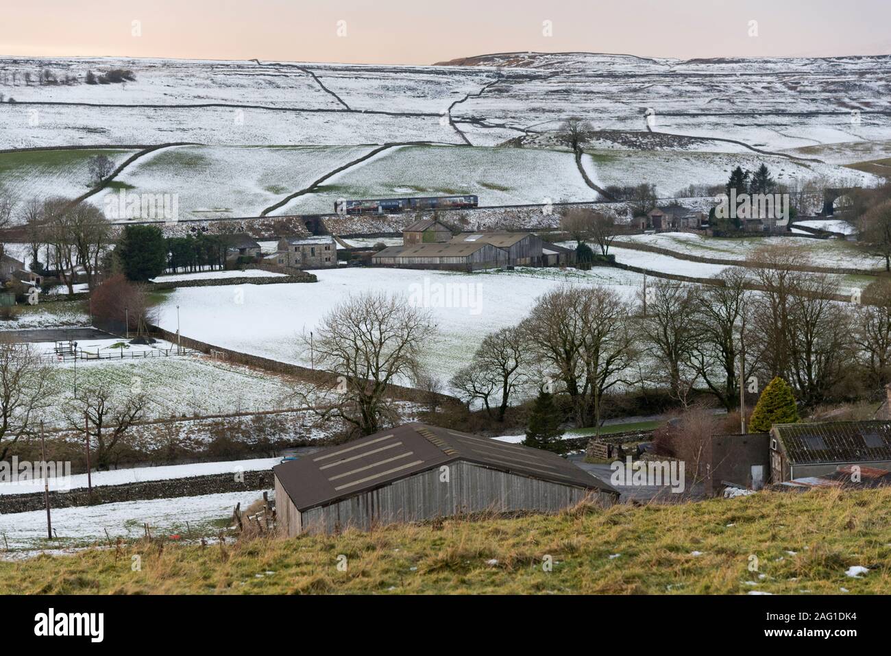 A Sprinter passenger train heads south on the Settle-Carlisle railway line amid a snowy scene at Horton-in-Ribblesdale, Yorkshire Dales National Park Stock Photo