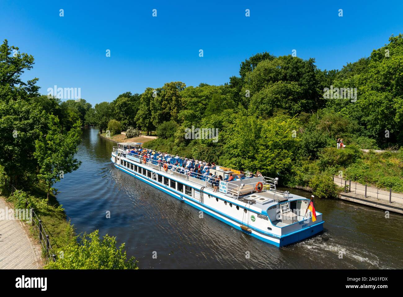 Tour boat travelling beside the Tiergarten along the Landwehr Canal, Berlin, Germany Stock Photo