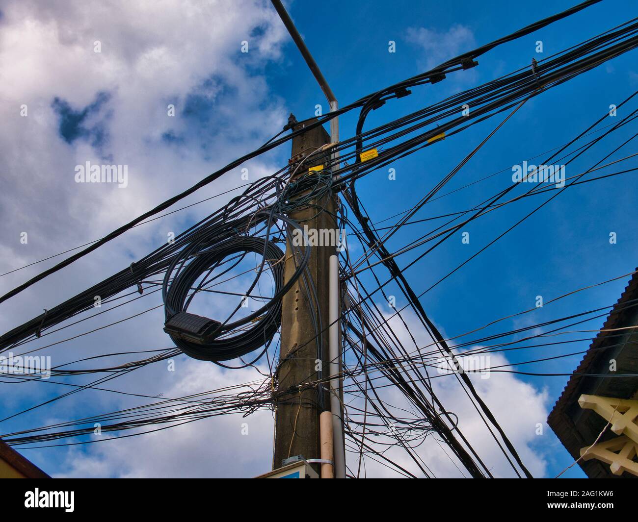 Chaotic electrical supply cabling on a pole on a street in Kampot, Cambodia Stock Photo