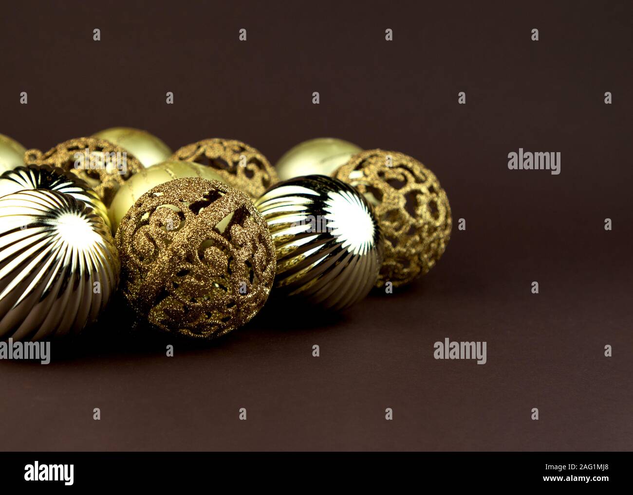 Golden sparkly Christmas balls on brown background. Magic holiday card. Christmas or New Year festive composition. Stock Photo
