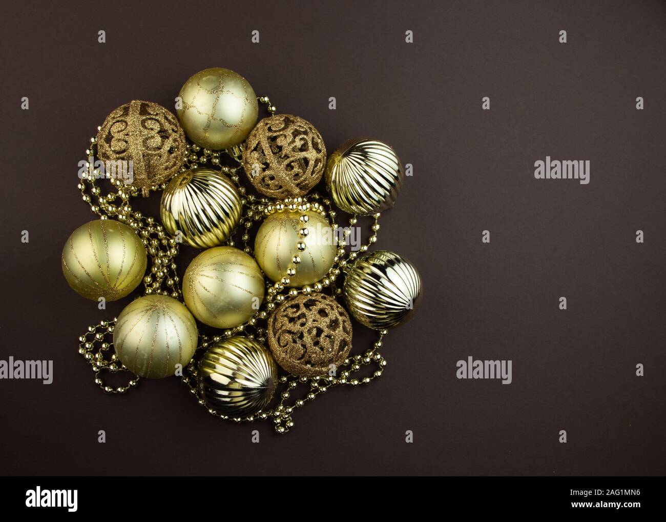 Golden sparkly Christmas balls on brown background. Magic holiday card. Christmas or New Year festive composition. Stock Photo