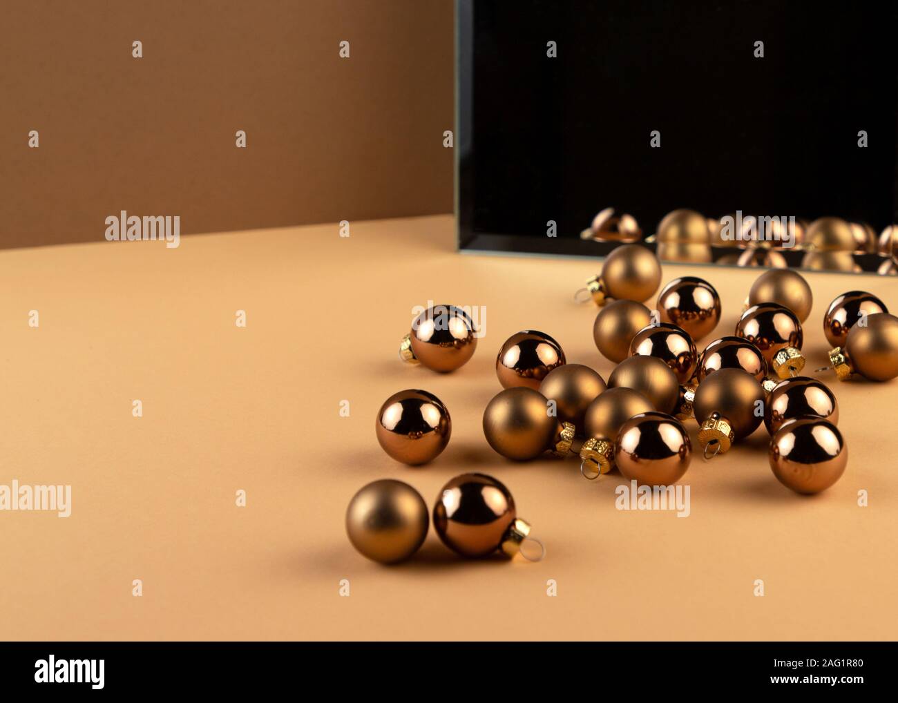 Reflection of group of christmas balls and shadow from balls in a mirror on beige surface. Stock Photo
