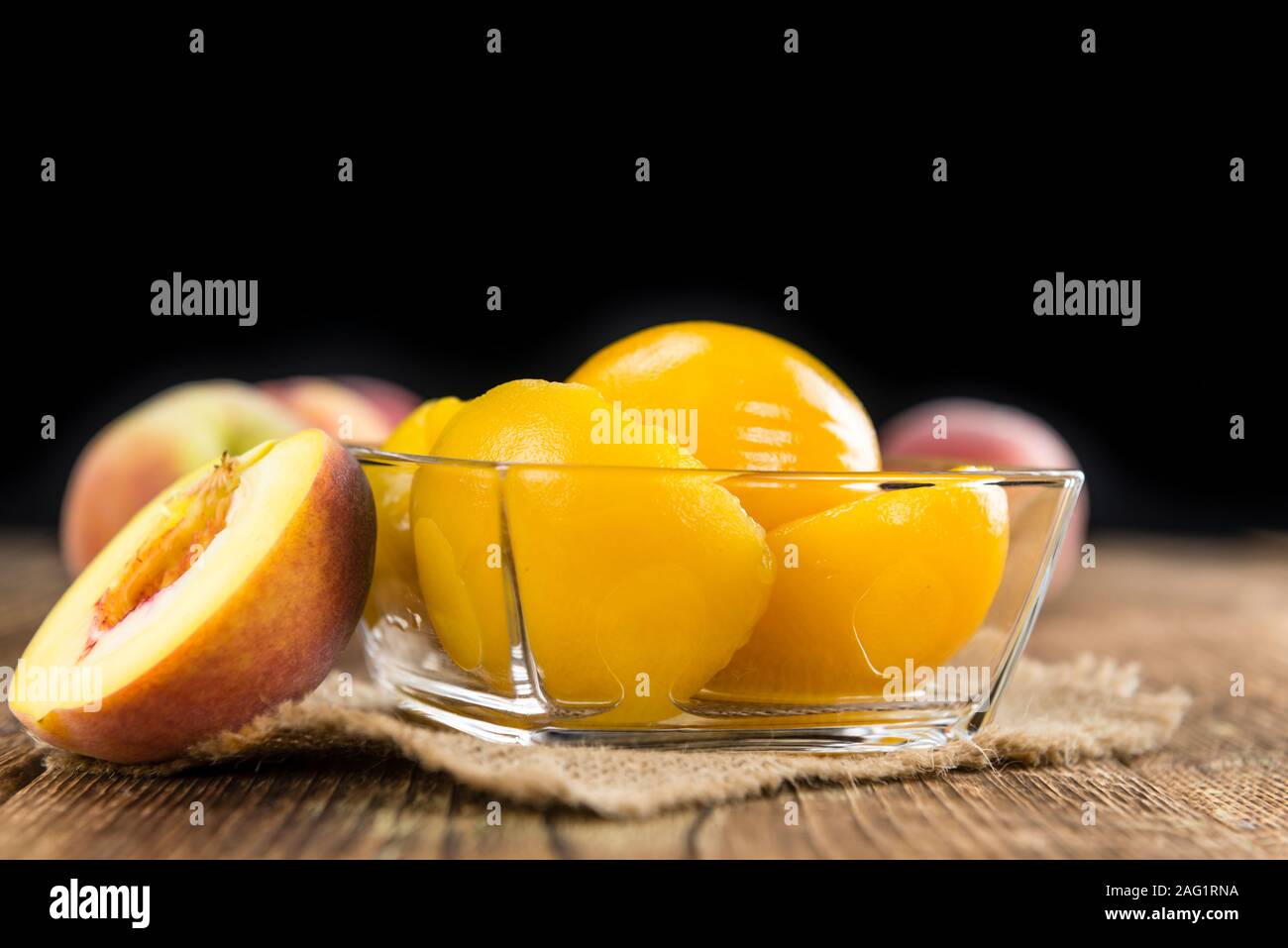 Some canned Peaches (detailed close-up shot) on vintage wooden background Stock Photo