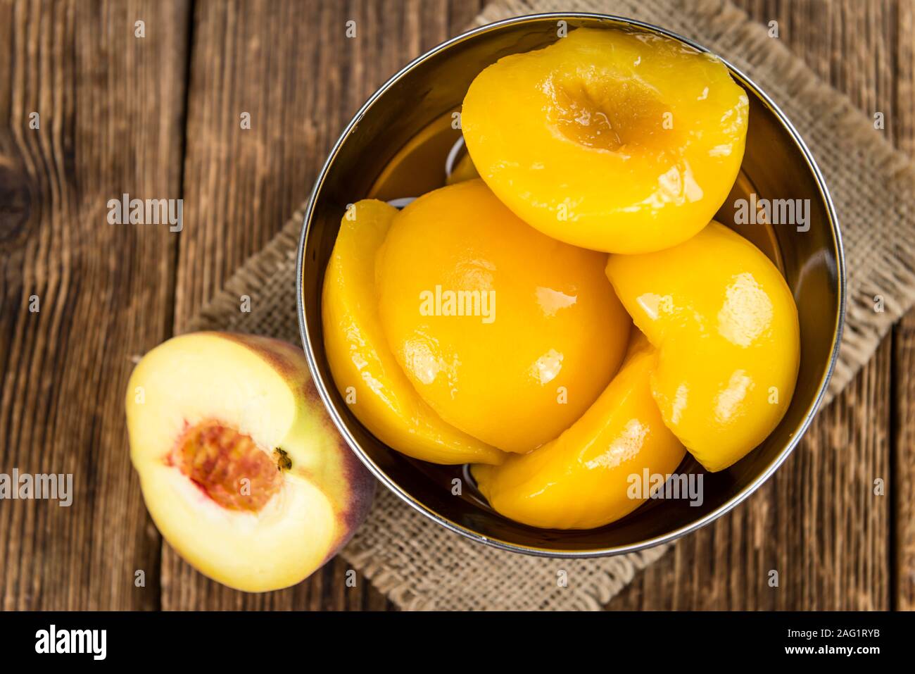 Preserved Peacheson an old wooden table (close-up shot) Stock Photo