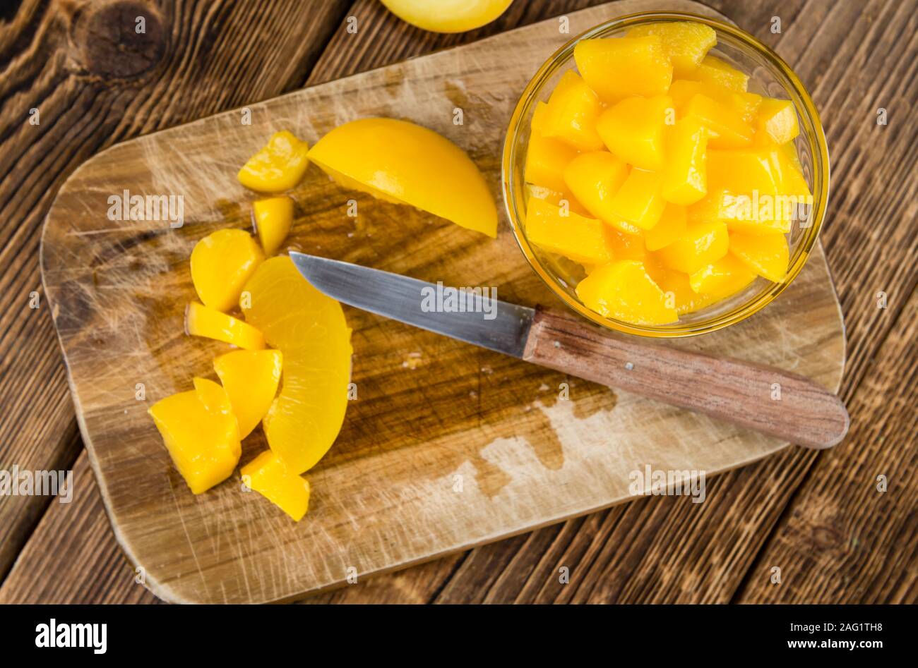 Preserved Peacheson an old wooden table (close-up shot) Stock Photo