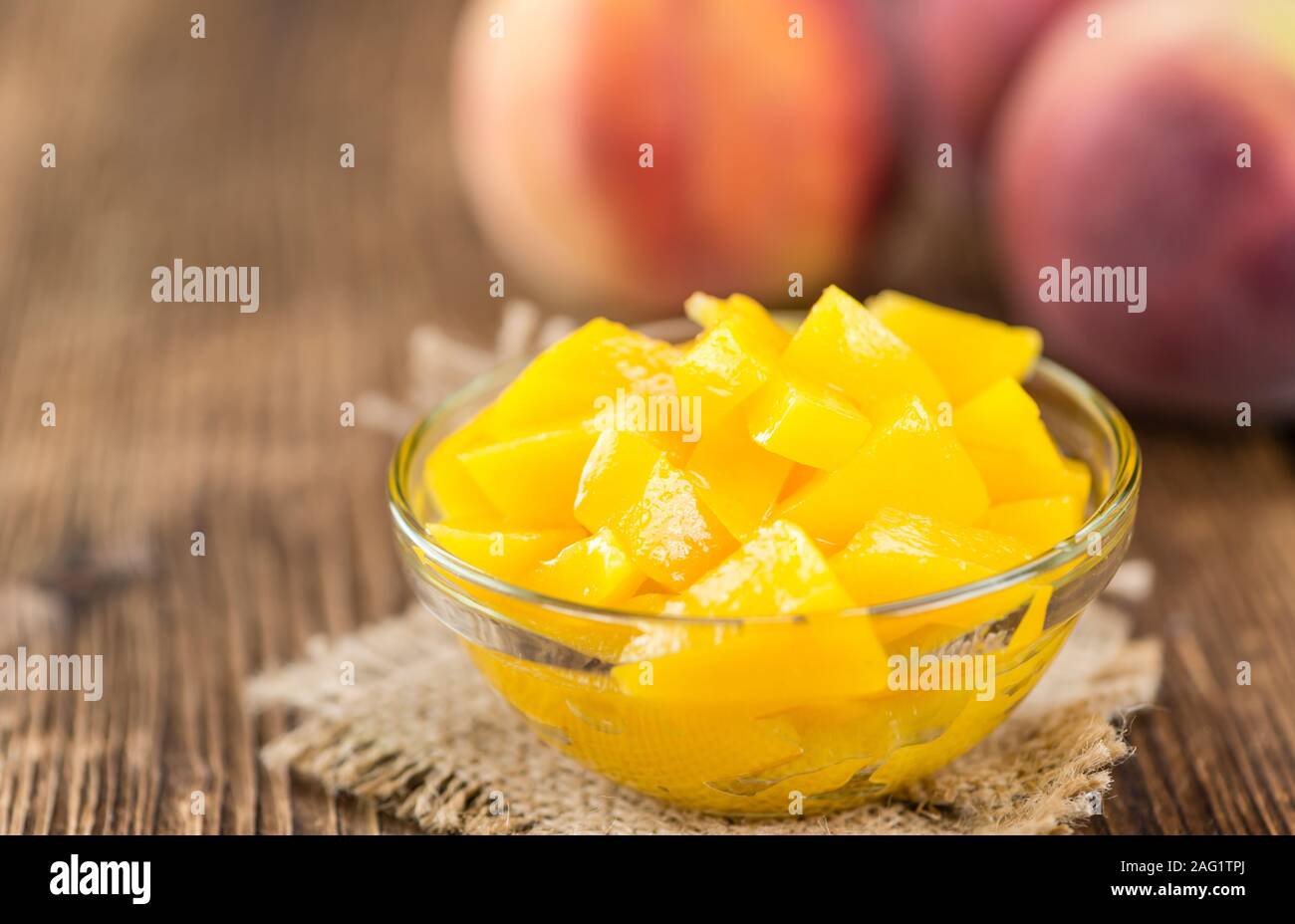 Some canned Peaches (detailed close-up shot) on vintage wooden background Stock Photo