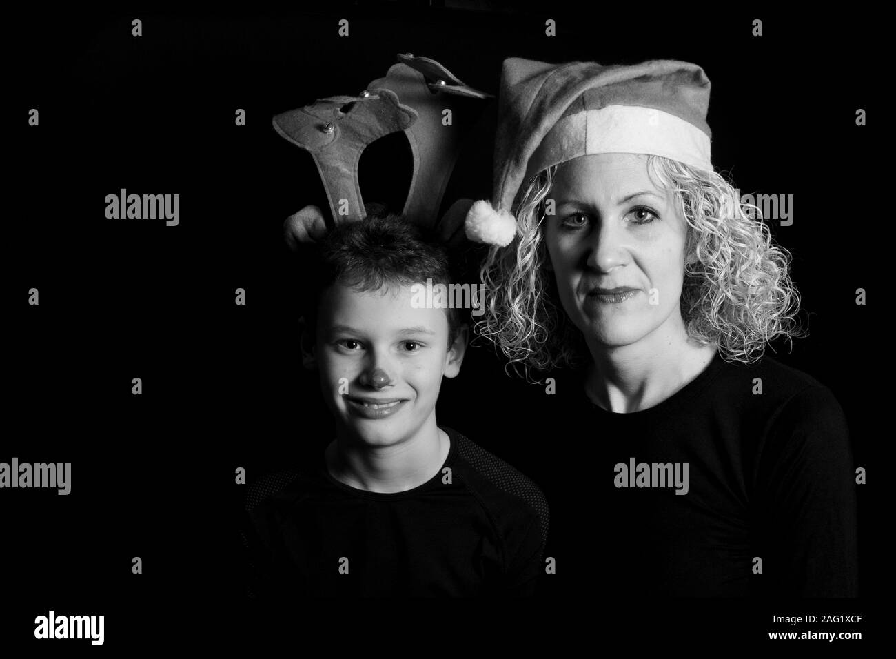 Boy with antlers and mother with Christmas cap in black and white Stock Photo