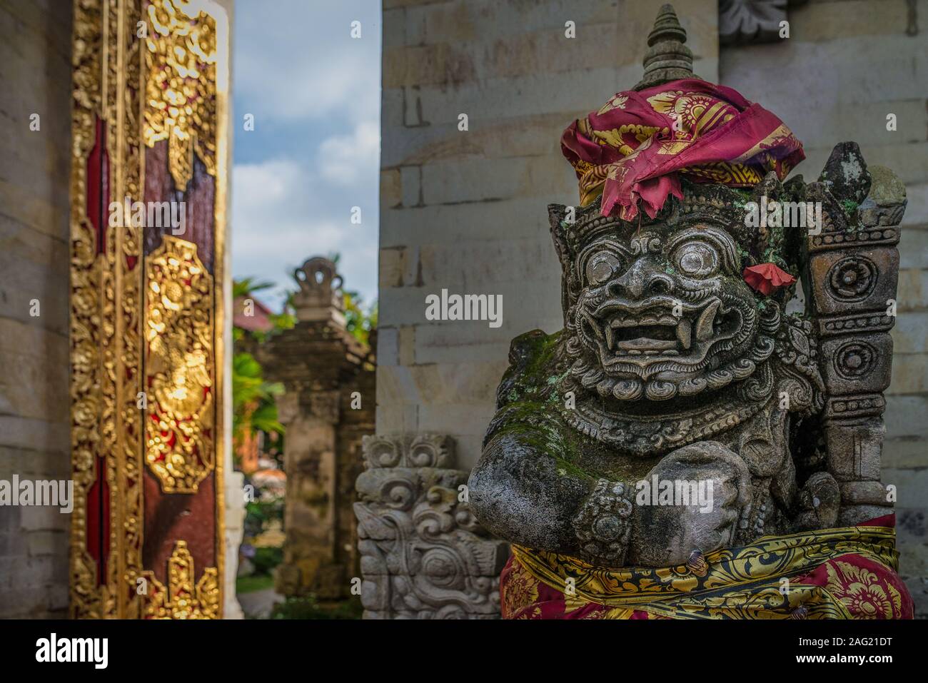 Traditional statue at the entrance of the Ubud Royal Palace, with golden door, taken on partly sunny afternoon, Ubud, Indonesia Stock Photo
