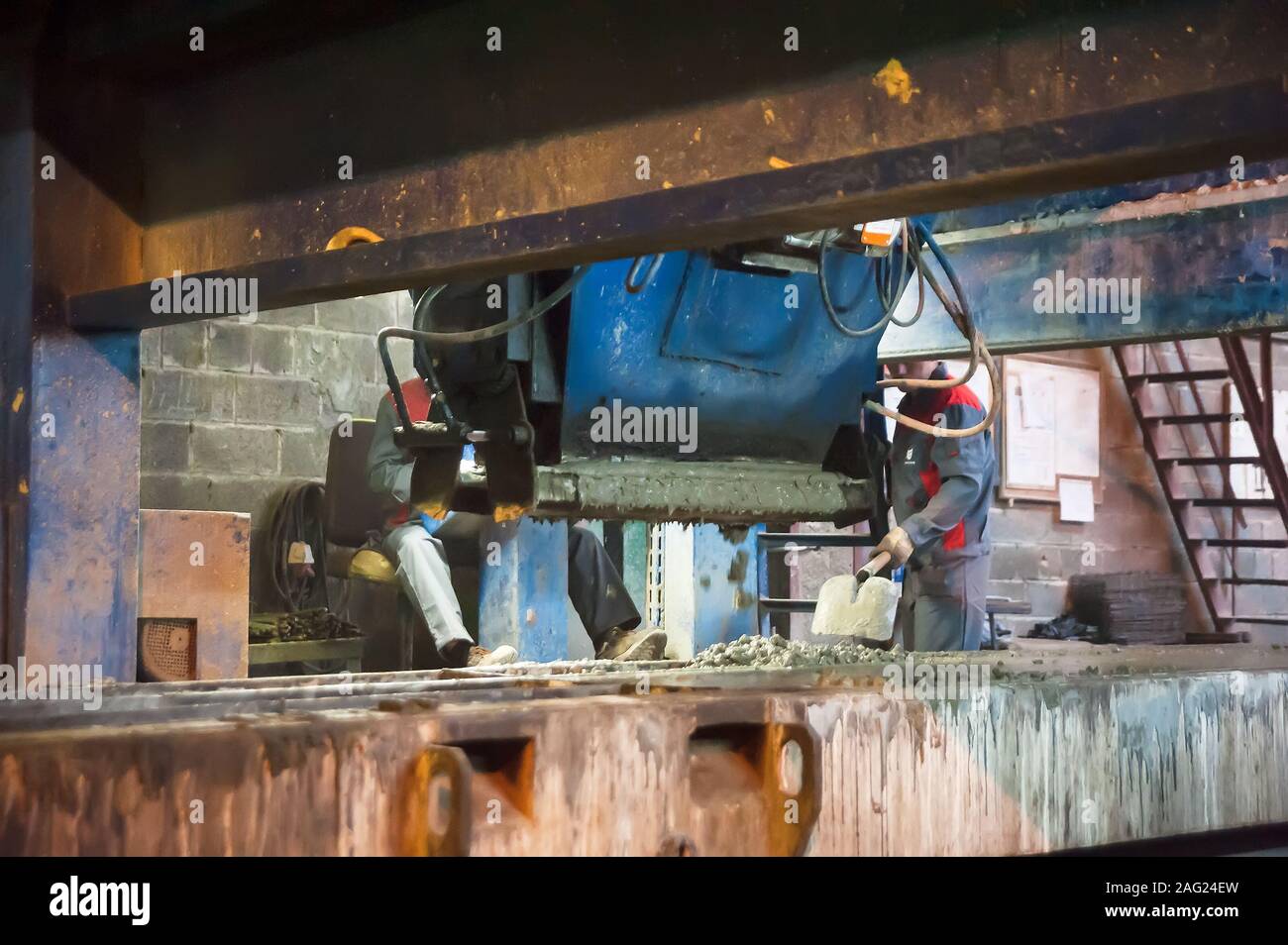 Workers operates machine with trowels Stock Photo