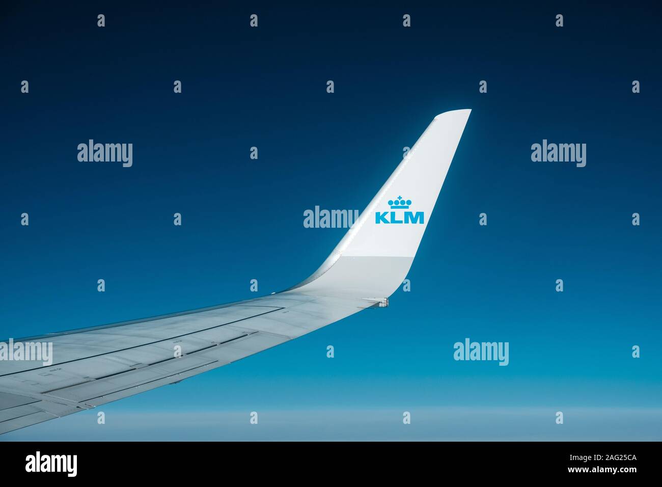 Amsterdam, Netherland - November, 2019: Airplane wing and company brand logo of KLM airlines isolated on blue sky Stock Photo