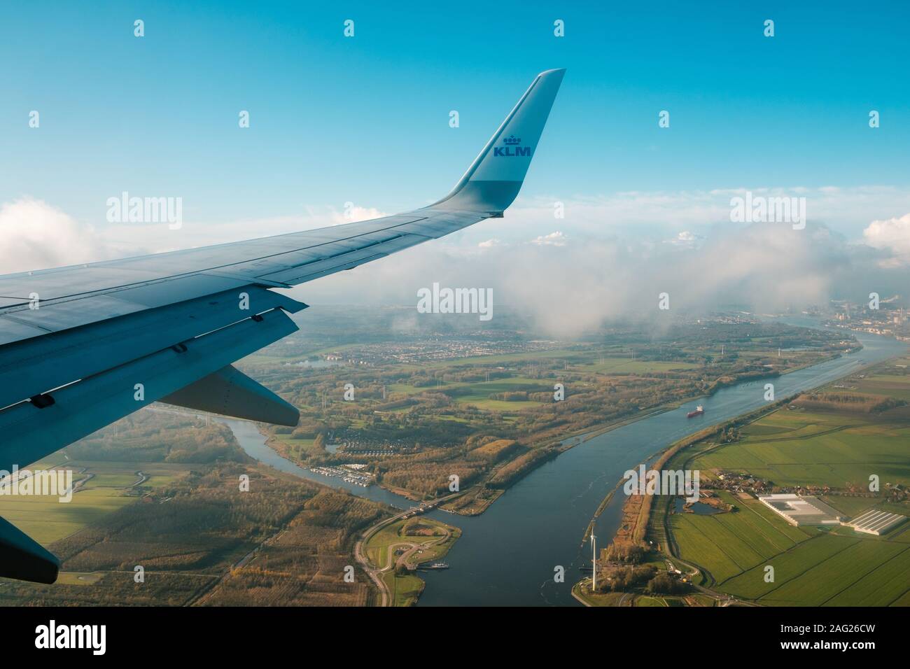 Amsterdam, Netherlands - November, 2019: Airplane wing and company brand logo of KLM Airlines and aerial landscape view from airplane Stock Photo