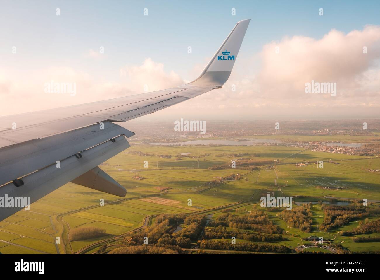 Amsterdam, Netherlands - November, 2019: Airplane wing and company brand logo of KLM Airlines and aerial landscape view from airplane Stock Photo