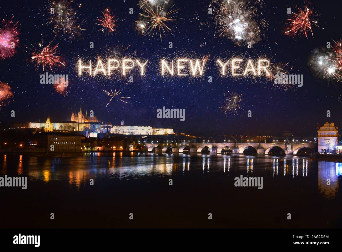 Happy New Year written with sparkle fireworks on night sky above Prague ...