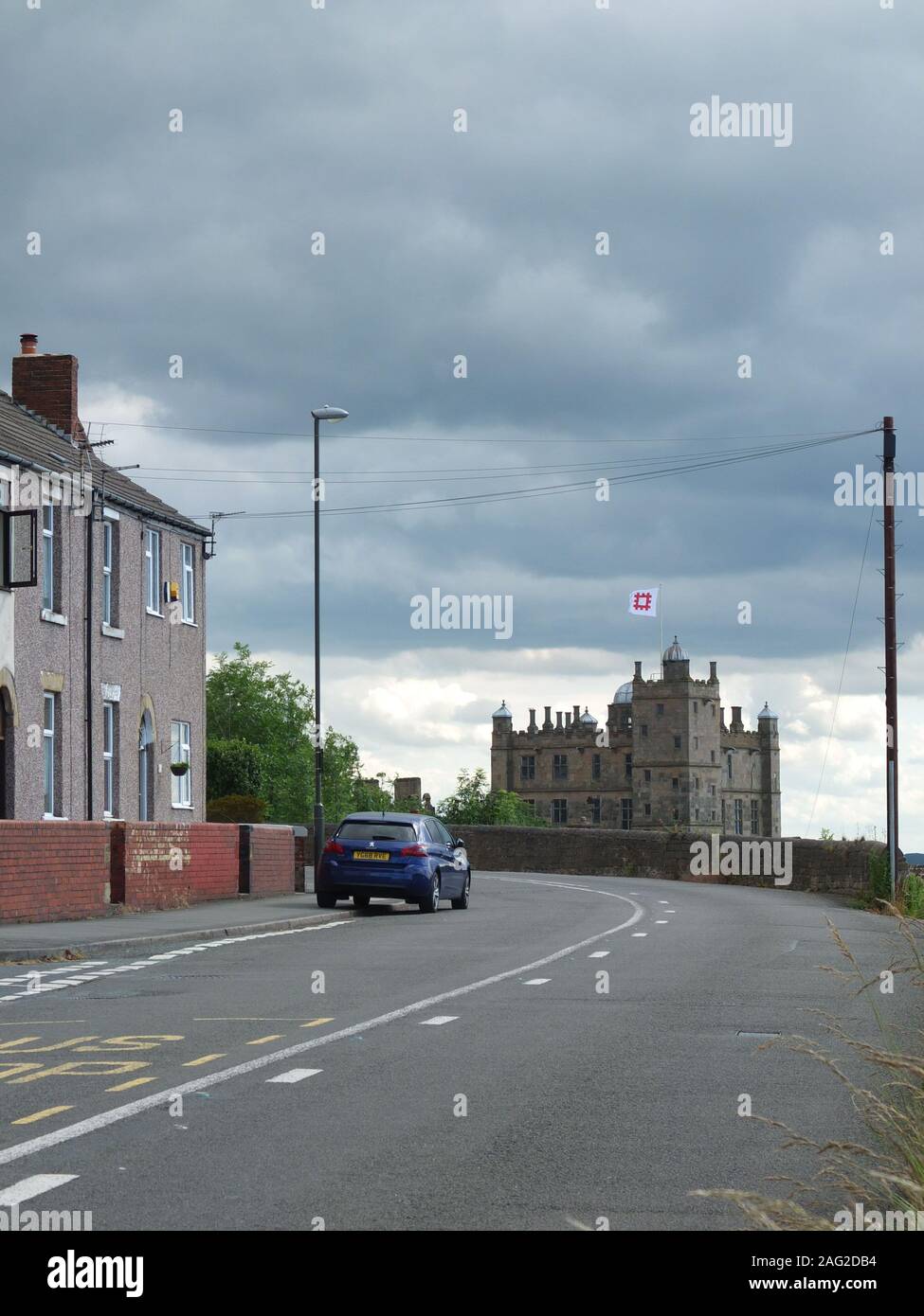 Hill Top at Bolsover, North East Derbysire. A street of terraced housing leading to Bolsover Castle with brooding grey skies above. Stock Photo
