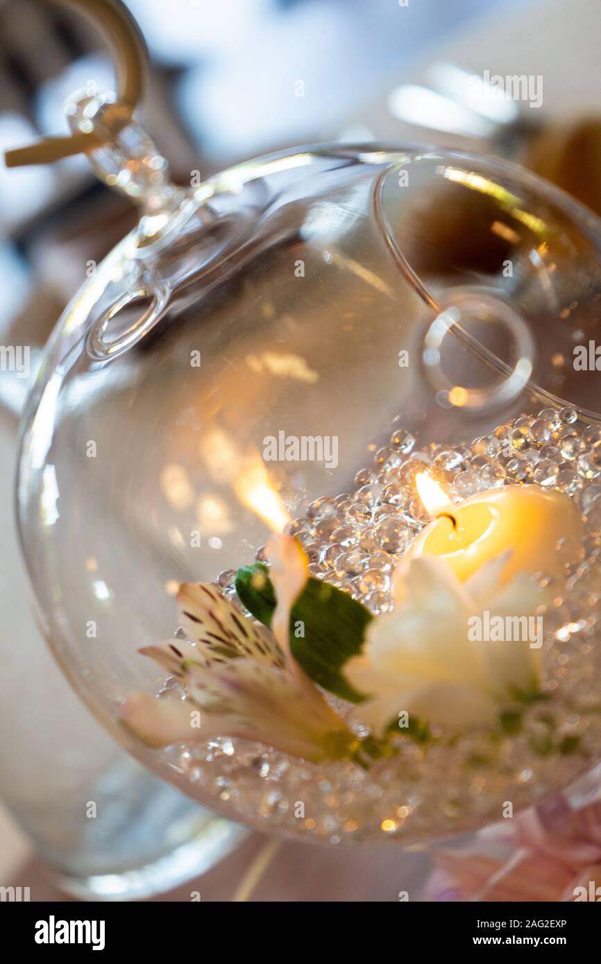 Candle inside a glass dish with flowers, table, decoration Stock Photo