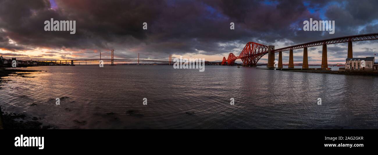 The Forth Bridges at sunset looking north across the Firth of Forth from South Queensferry Stock Photo