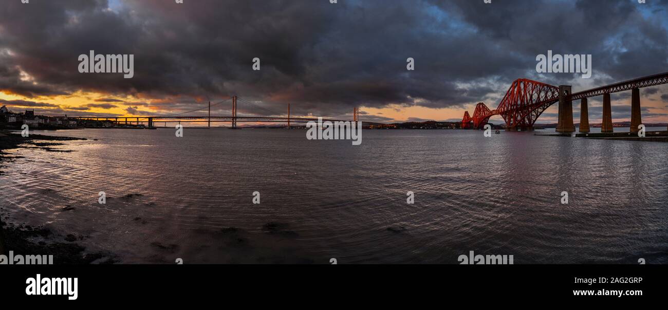 The Forth Bridges at sunset looking north across the Firth of Forth from South Queensferry Stock Photo