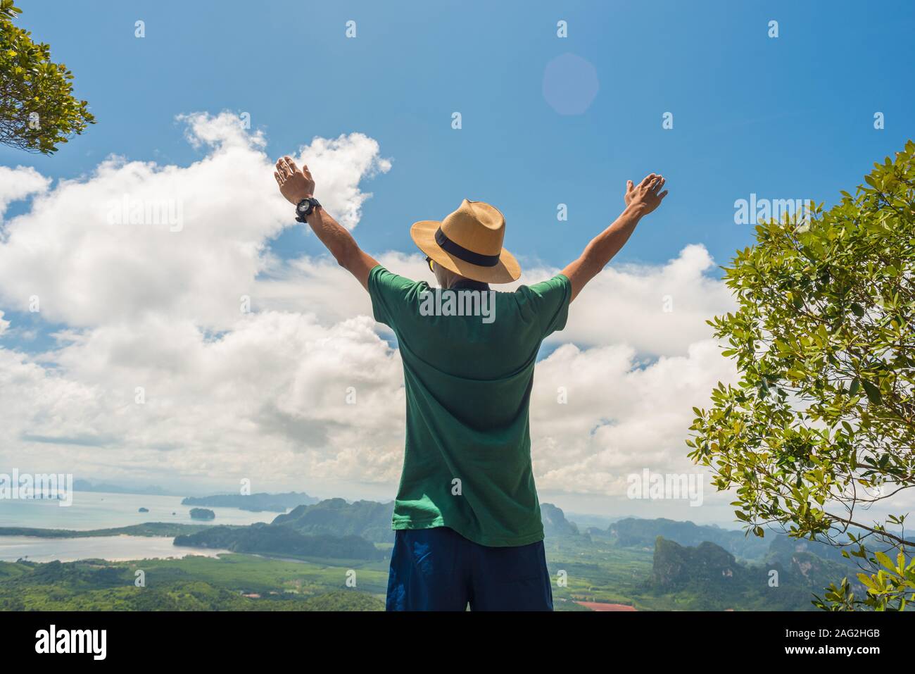 Stock image: a person with hands raised up stands on top of mountain. Concept of success, healthy lifestyle, harmony with nature & travel on vacation Stock Photo