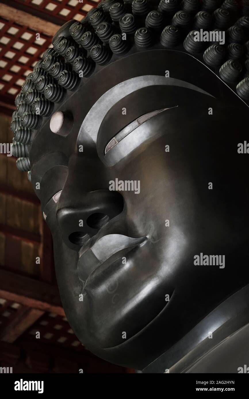 Artistic closeup of Buddha face. The Great Buddha statue of Todaiji main hall, Daibutsuden, Todai-ji temple, Nara, Japan. Stock Photo