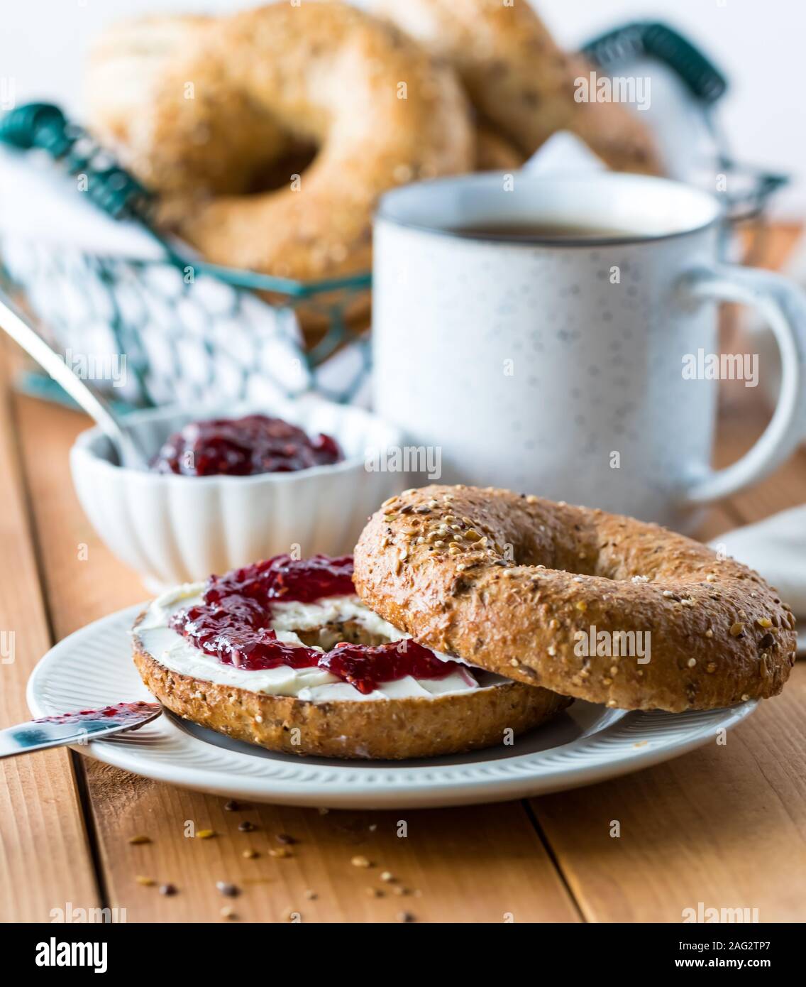 A multi grain bagel with cream cheese and jam. Stock Photo