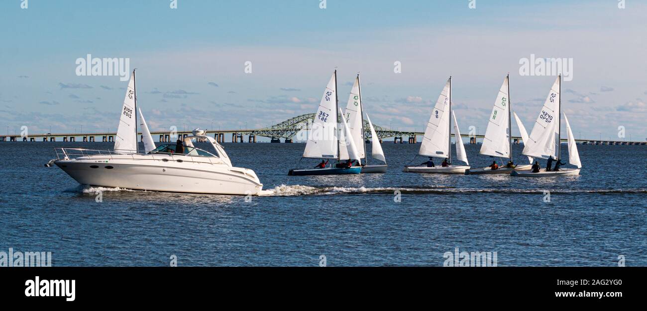Babylon, New York, USA - 7 December 2019: A snowflake sailboat regatta in December 2019 in The Great South Bay has many two person sailboats and a mot Stock Photo