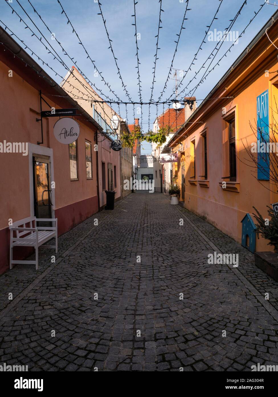 Street in the old part of Varazdin, Croatia. A street known for its small shops and galleries. Part of the street is covered with green leaves. Advent Stock Photo
