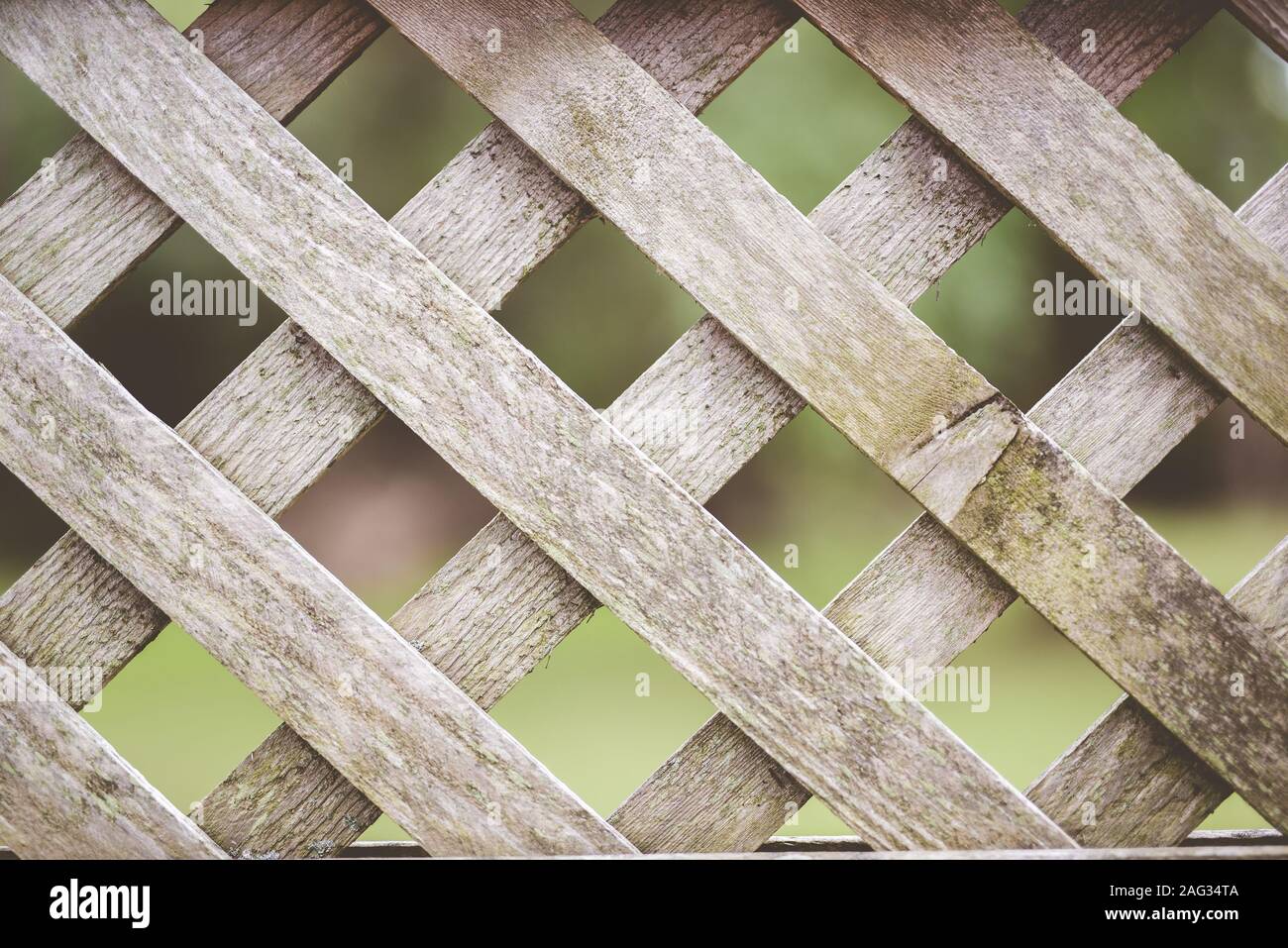 Closeup shot of a wooden criss-cross fence with a blurred background - great for a background Stock Photo