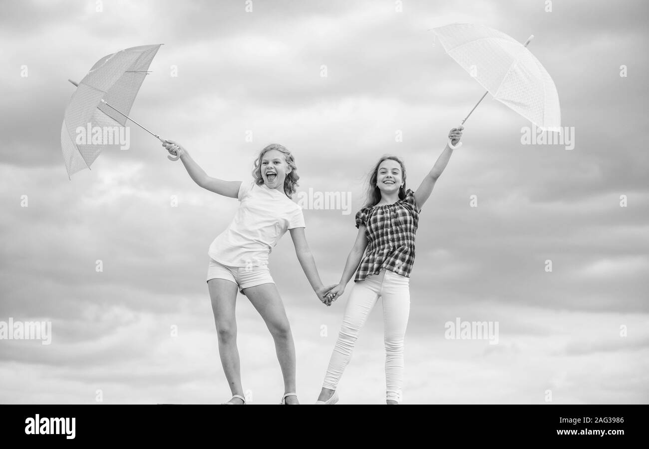 Time to rest. fall kid fashion. Feeling protected at this autumn day. happy small girls with umbrella. positive and bright mood. best friends. school time. autumn season. rainy weather forecast. Stock Photo