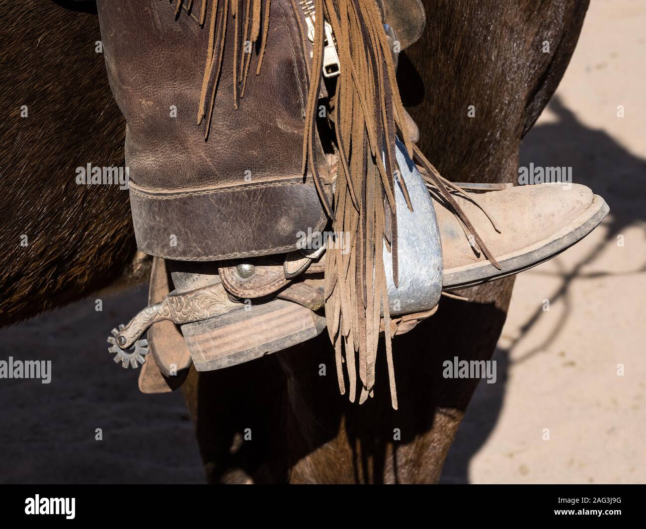 Close up detail of a cowboy's boot in a saddle stirrup with leather