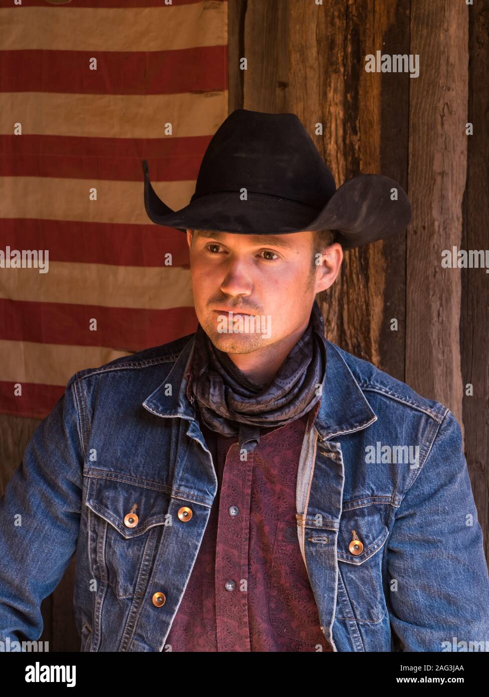 A working cowboy wrangler poses in his cowboy hat, bandana and chaps in  front of an American flag on the Red Cliffs Ranch near Moab, Utah Stock  Photo - Alamy