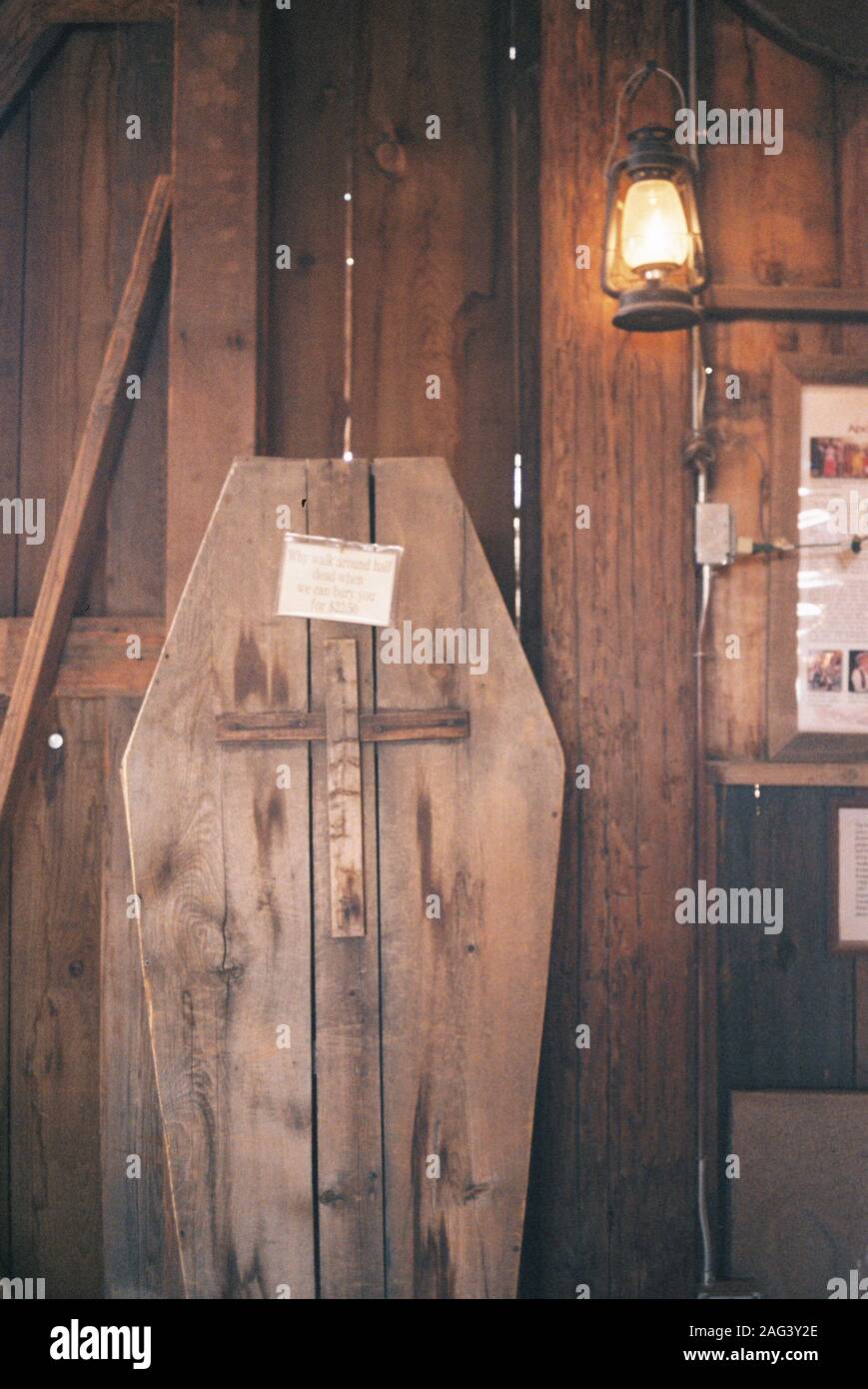 A Vertical Shot Of A Coffin Made With Plywood With A Cross Carving