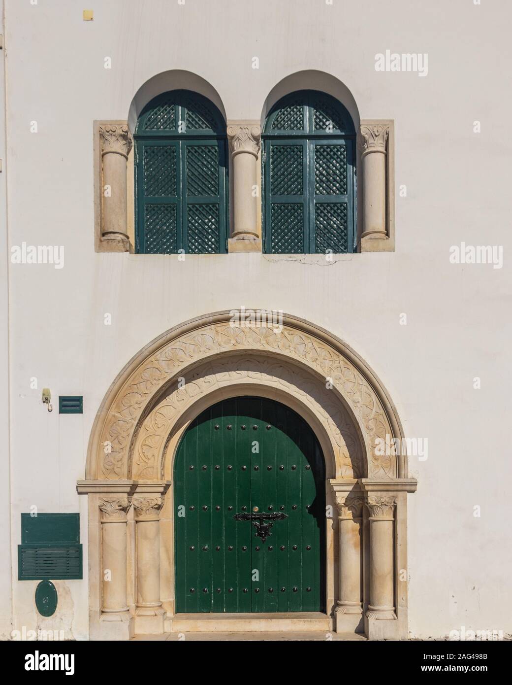 A Vertical Shot Of A Building With Arch Shaped Green Windows