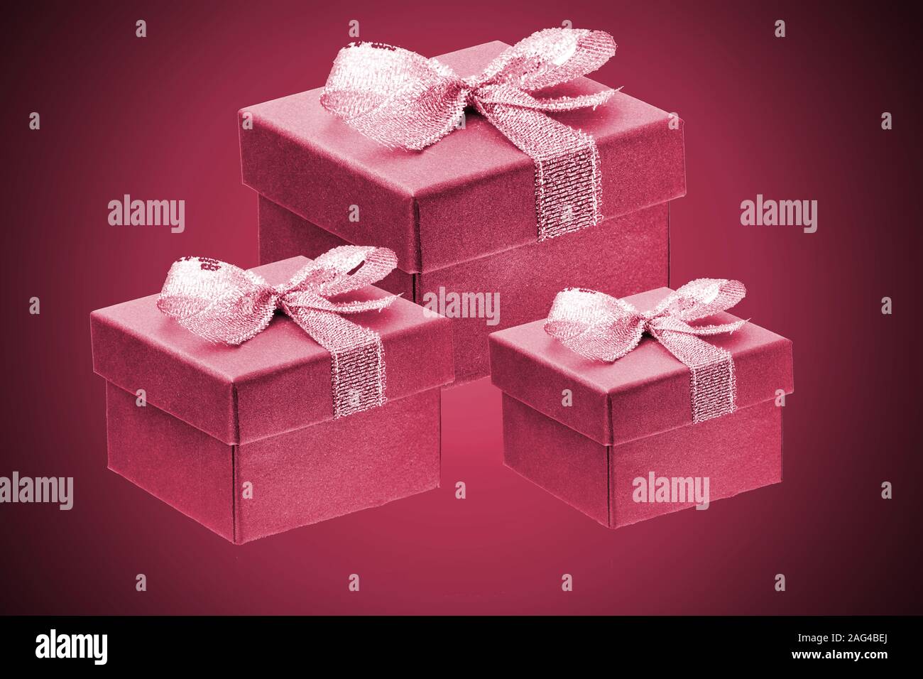 three purple gift boxes on a red gradient background. close up. Stock Photo