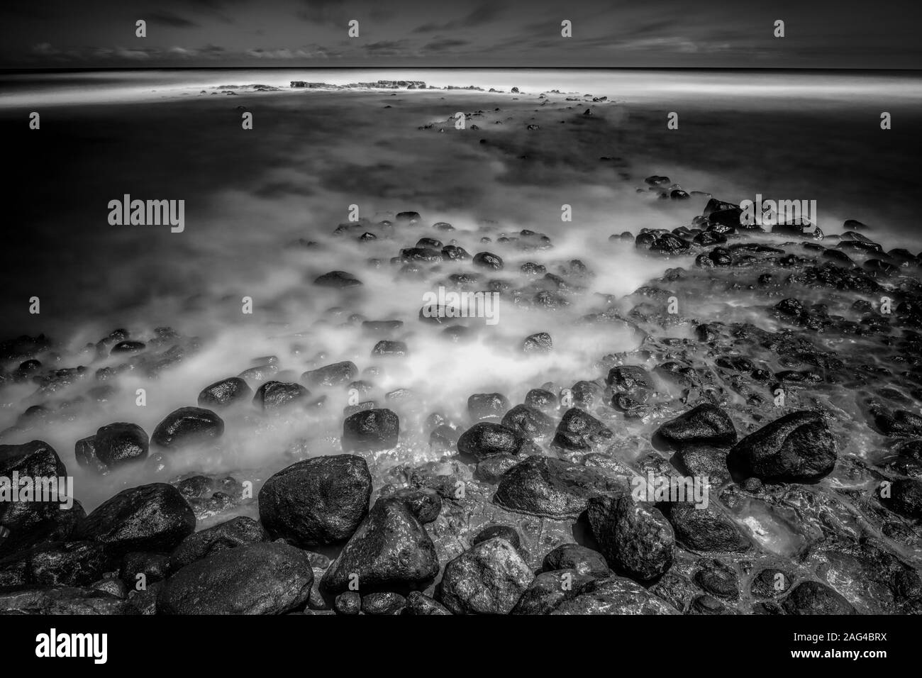 Greyscale Rocks Greyscale mystic view of rock formations laying under the sea waves ...