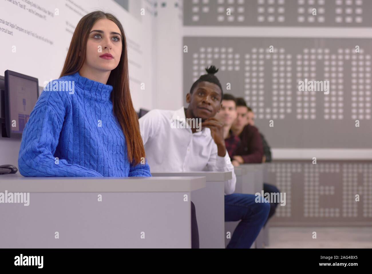 Side view of students using computer in lab. IT student looking and ...