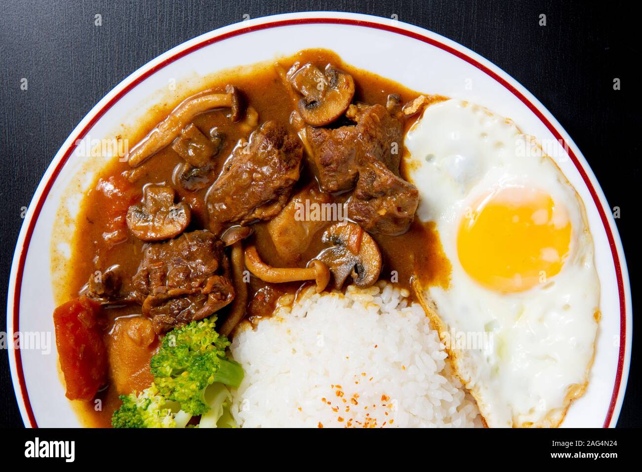 beef Curry Rice on black wooden background ( Onsen tamago, Potato, enoki mushroom, onion