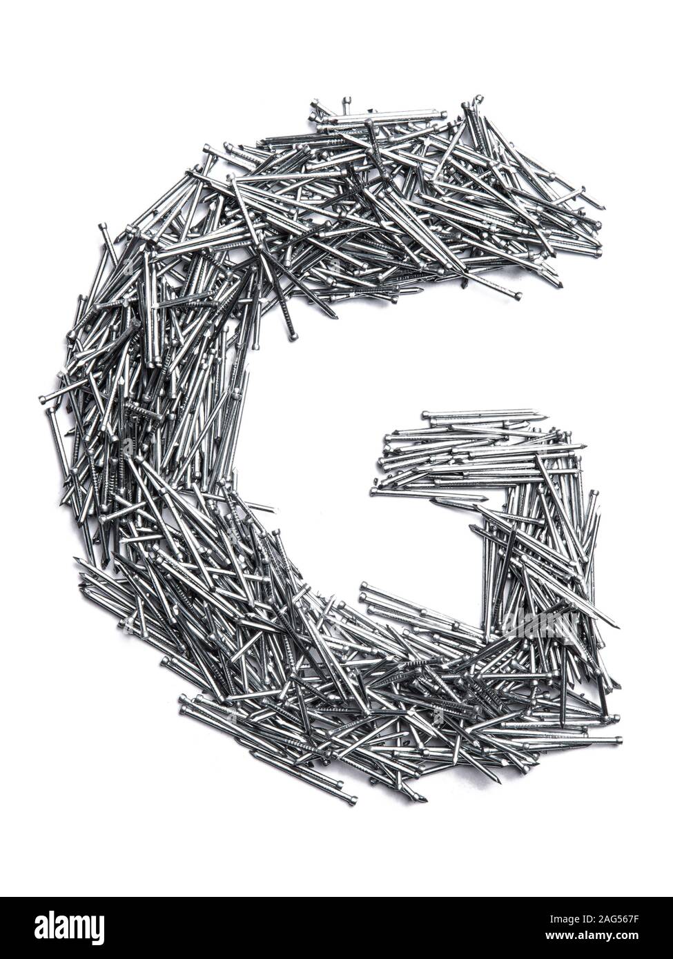 Letter G of the English alphabet from small iron nails on a white isolated background