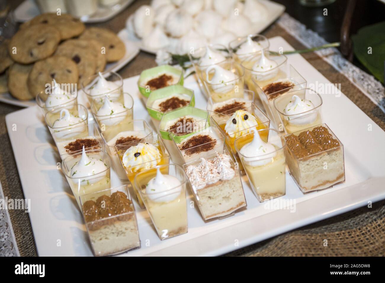 Tray of small sups of desserts with chocolate and cream garnish and some cookies Stock Photo