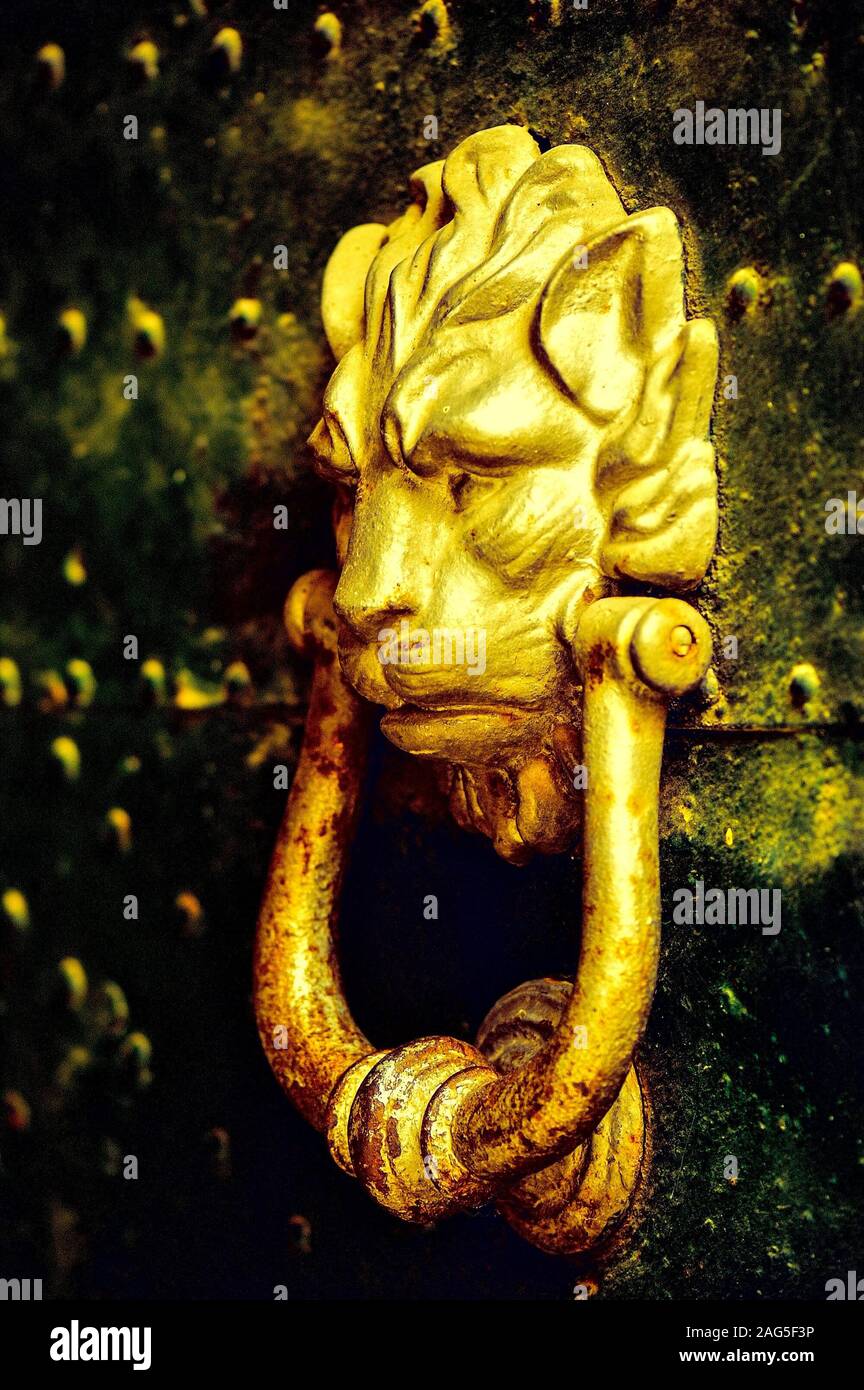 Vertical closeup shot of an ancient golden door holder with a lion