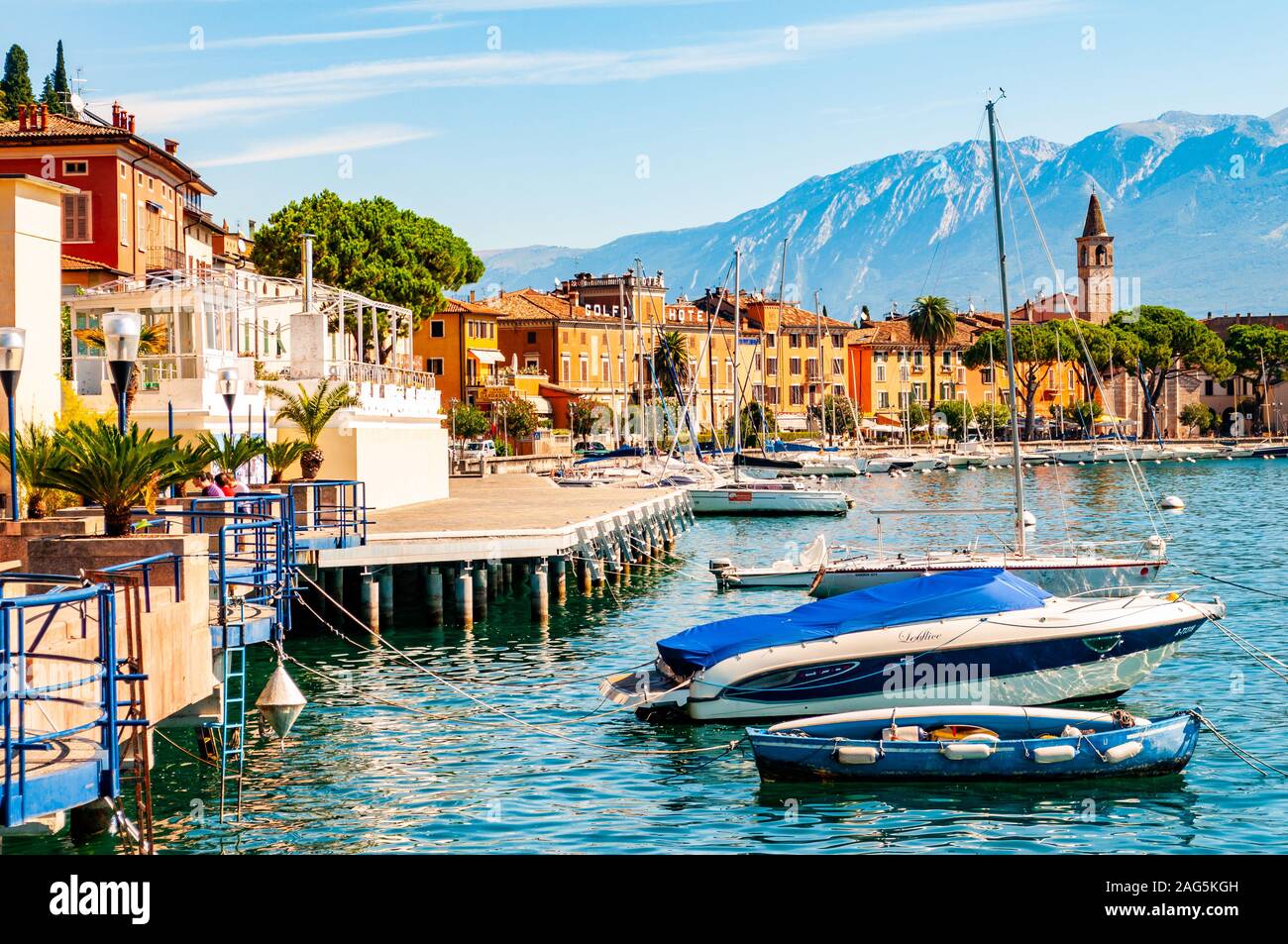 Toscolano Maderno, Lombardy, Italy - September 12, 2019: View on sailing yachts and boats parked on crystal clear blue water of amazing lake Garda and Stock Photo