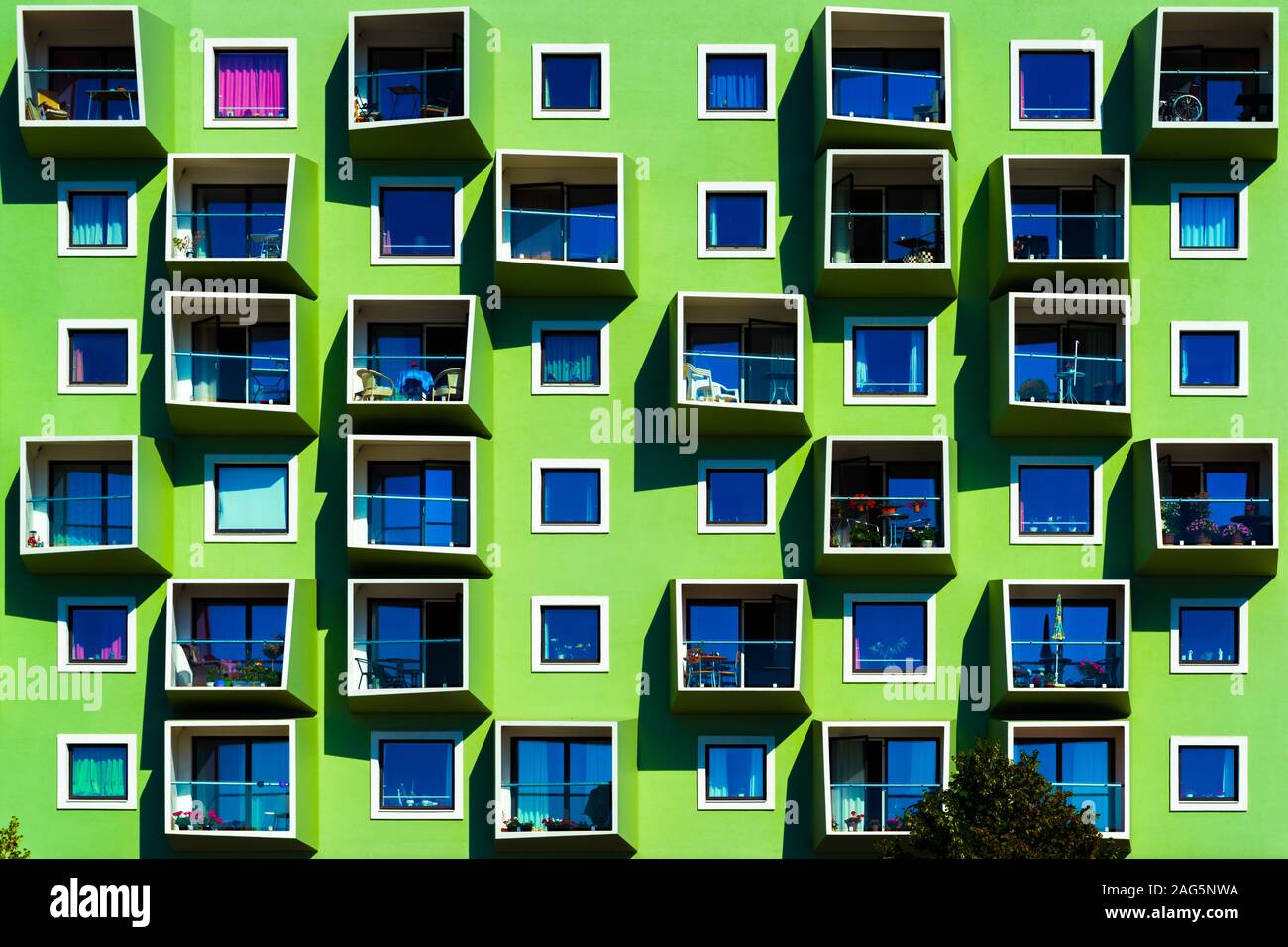 Happy green modern building with different kinds of plants on balconies ...