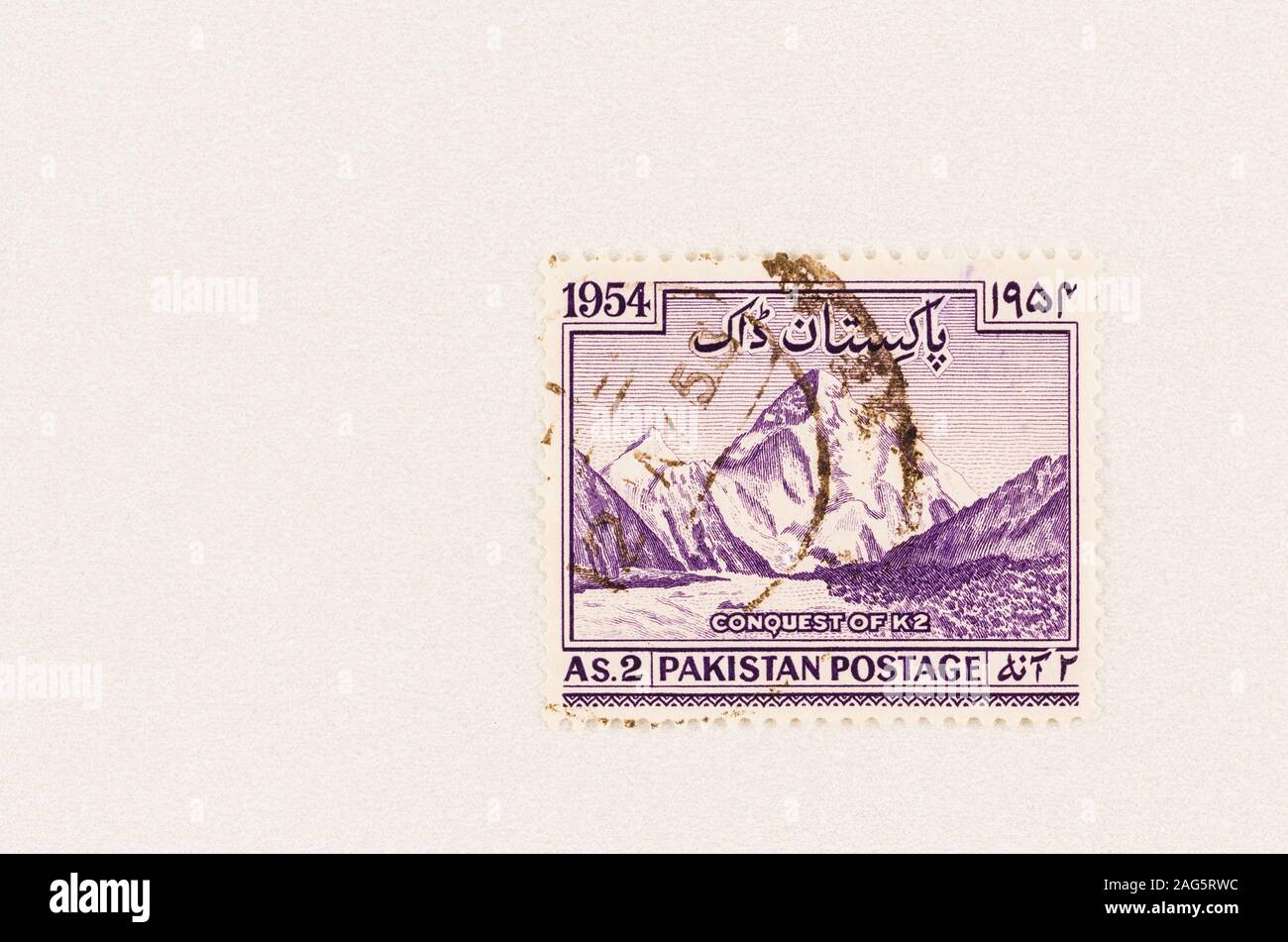Purple Pakistan stamp with mountain and Conquest of K2 , 1954, aka Mount Godwin Austen,  of Karakoram range. Stock Photo