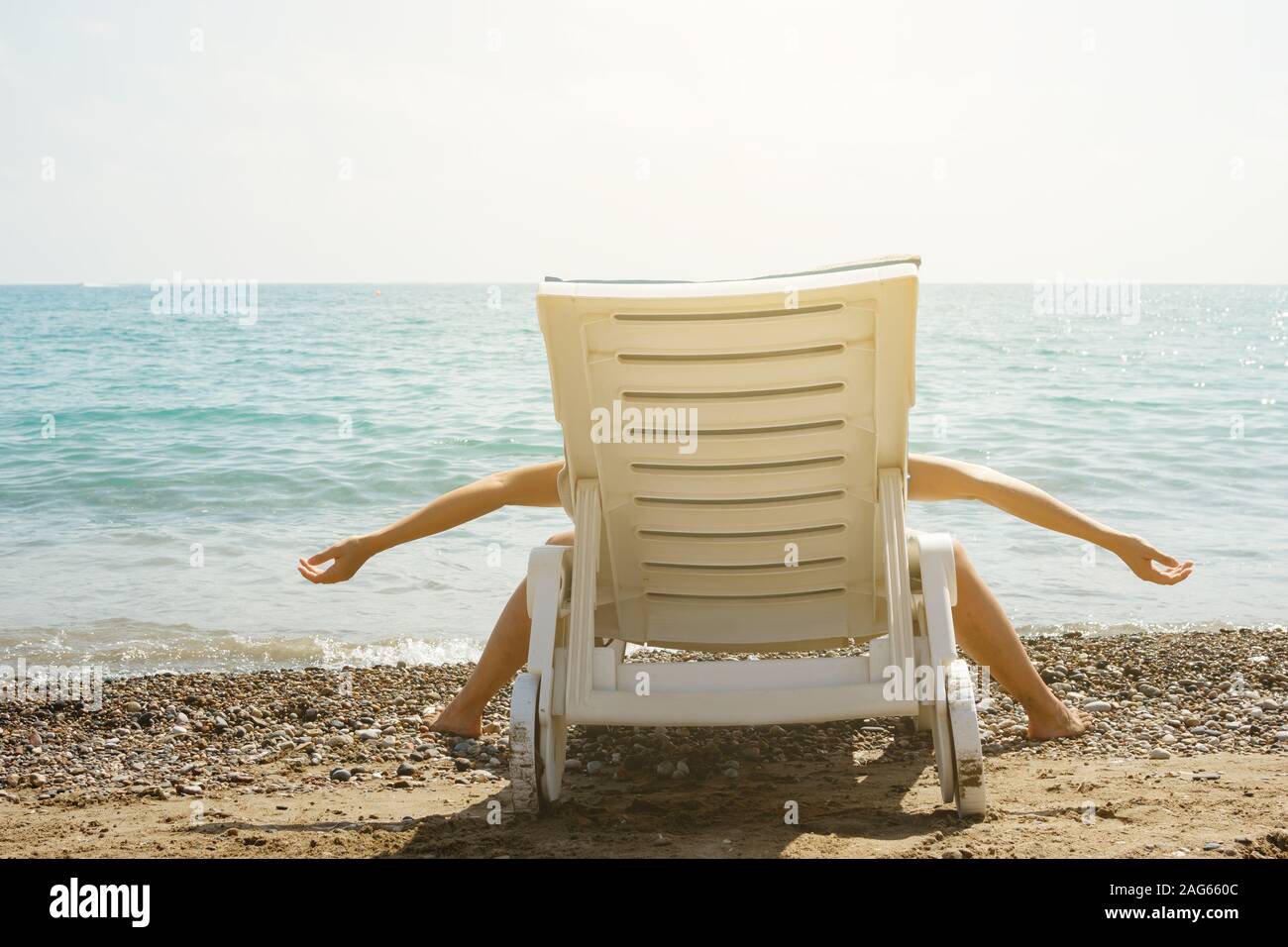 Woman is lying on the sunbed in funny pose. She is tired and enjoy her