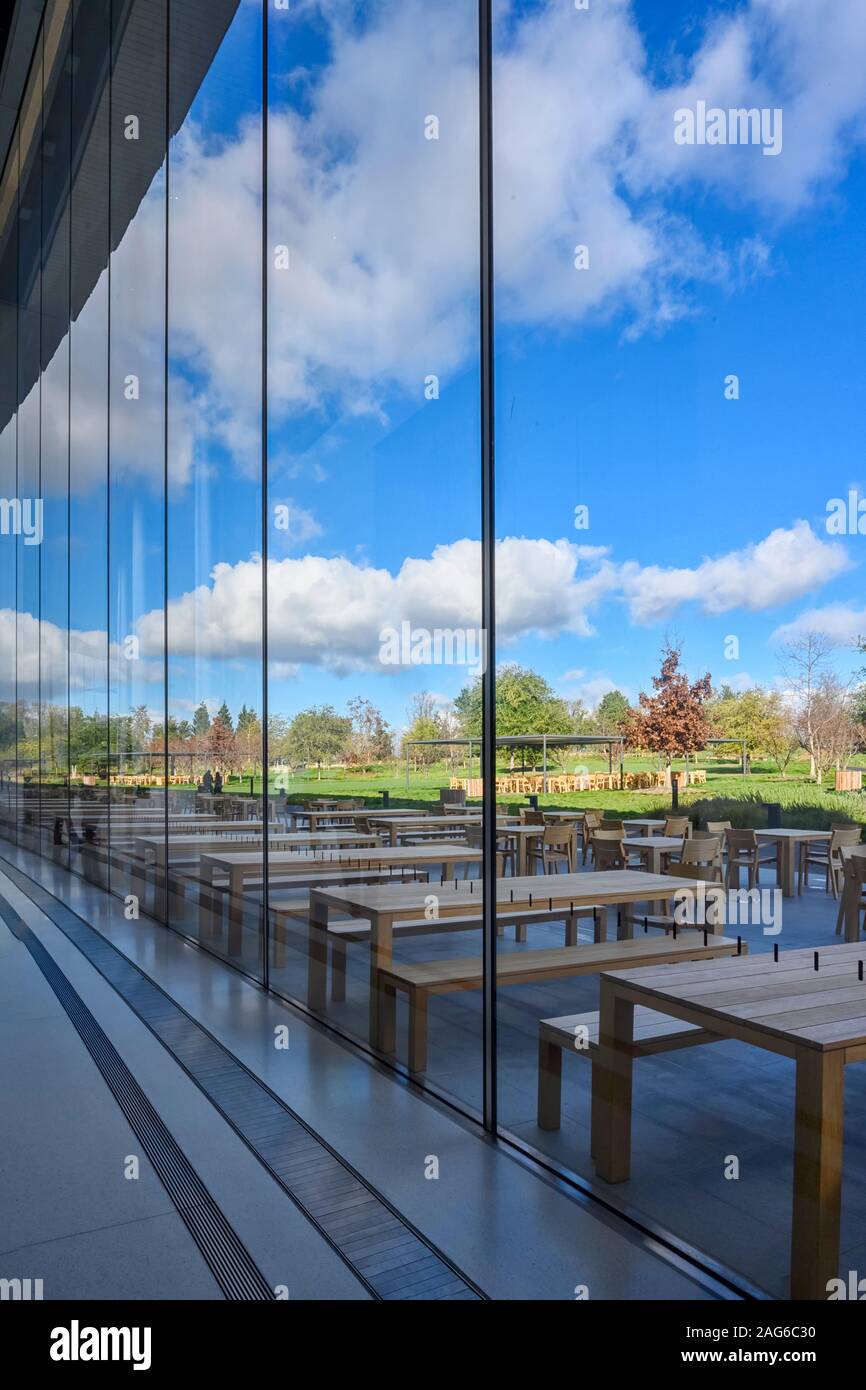 Cupertino CA USA December 14, 2019: Apple headquarters offices building, looking through the glass window from inside a side entrance to the outdoor e Stock Photo
