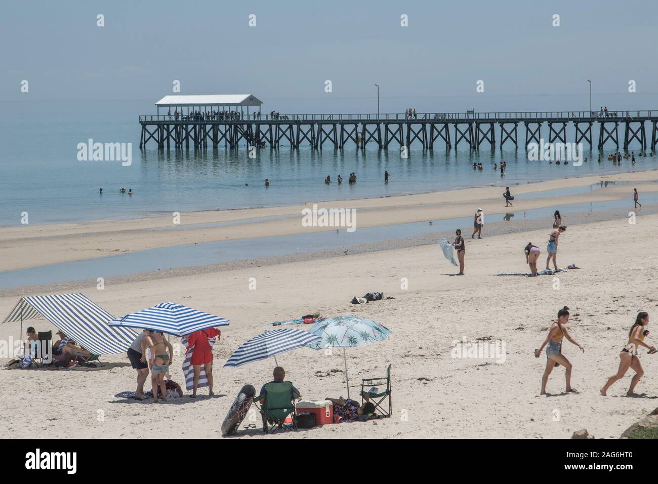 Adelaide, Australia. 18 December 2019.Beachgoers in the coastal suburb of Glenelg Adelaide during extreme  hot weather  with record temperatures for December. A  Code Red alert has been issued for Adelaide and across South Australia ahead of a heatwave which is expected to deliver extreme temperatures exeeding 40Celsius over the next coming days. Credit: Amer Ghazzal/Alamy Live News Stock Photo