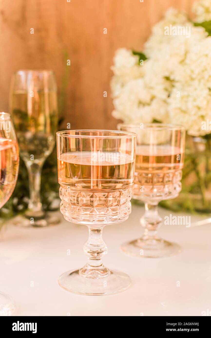 Rose blush wine in glasses. Bottle of rose wine with flowers on