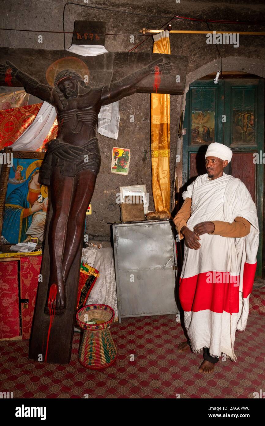 Ethiopia, Amhara, Lalibela, Mount Abuna Yosef, inside, Asheton Maryam Monastery, priest with large carved wooden crucifixion Stock Photo